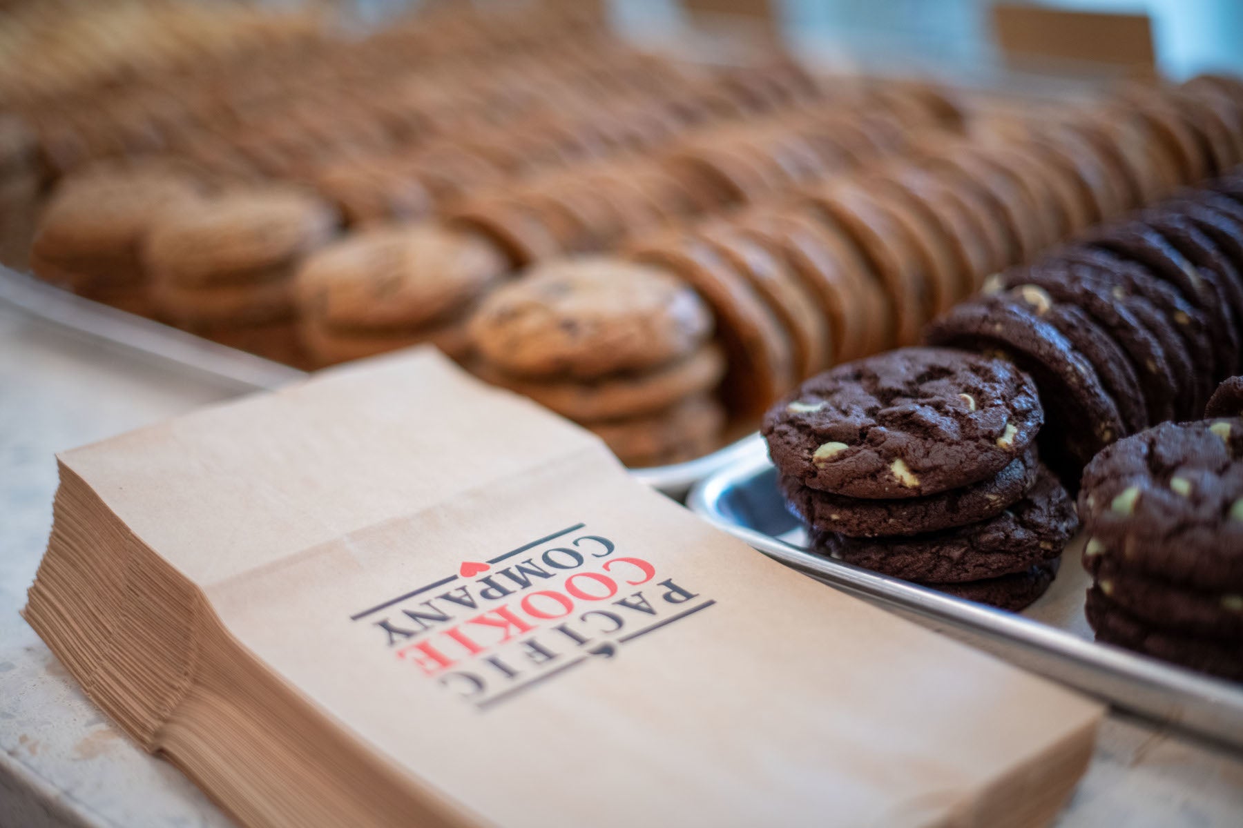 Trays of cookies with Pacific Cookie Company bags